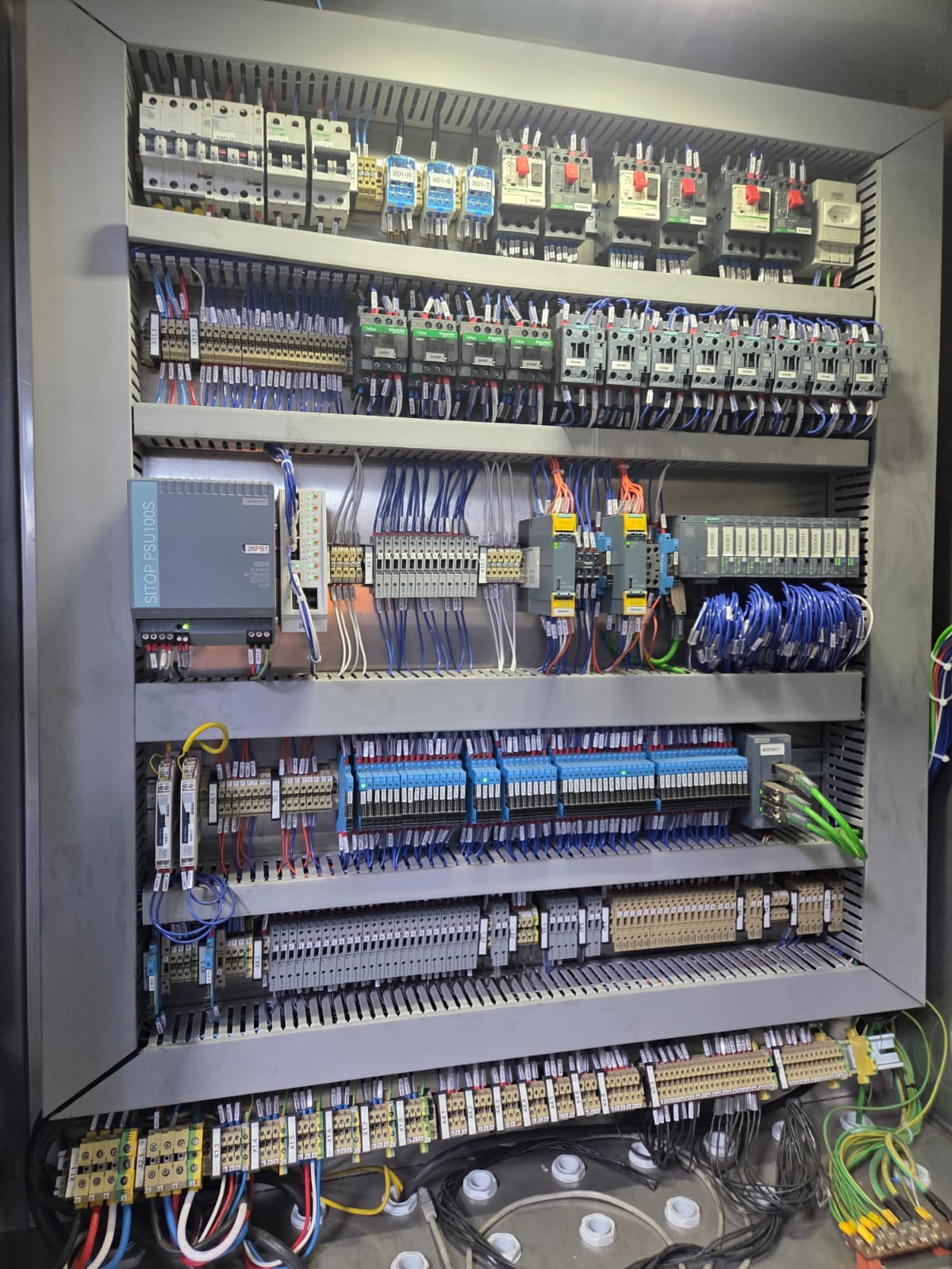 Interior de painel elétrico com disjuntores, contatores e cabeamento identificado